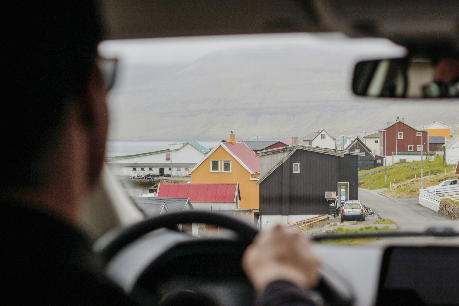 white hatchback car ahead parked beside grey building